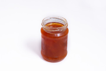 Glass jar of jam on a white background