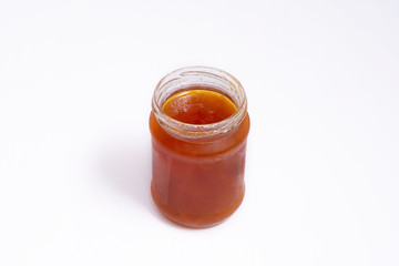 Glass jar of jam on a white background