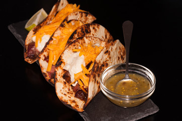 Mexican food. Taco - Steak with fried onions, cheddar cheese, salsa verde sauce and jalapeno mayonnaise