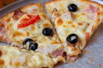 A piece of hot pizza on a metal mold. Leftover Pizza