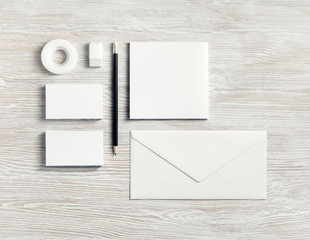 Blank corporate stationery for branding design. White ID set on light wood table background. Flat lay.