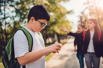 Obraz premium Boy using smart phone at schoolyard