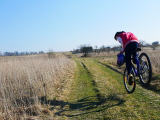 Obraz premium Polonne / Ukraine - 30 March 2019: Young cyclist standing on front wheel on trial bike. Sportsman rider balancing on the edge of big on sunny day. Concept of extreme sport active