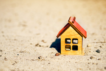 Fototapeta na wymiar Small wooden house on a ground, shallow depth of field. Conceptual image of purchase, sale, lease of the house, ecology house