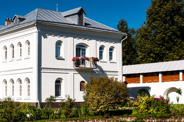 Tolga monastery garden and white historical building in sunny summer day