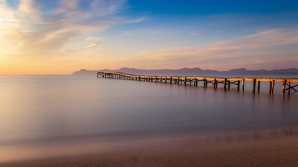 Wooden pier / jetty, playa de muro, Alcudia, sunrise, mountains, secluded beach, golden sunlight, reflection, beautiful sky, clouds,landmark, mallorca, spain.