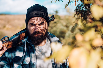 Hunter with shotgun gun on hunt. Close up Portrait of hamdsome Hunter. Man holding shotgun. Track...