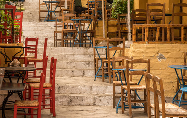 Empty Taverna on steps in ancient neighborhood of Plaka in Athens by the Acropolis - obrazy, fototapety, plakaty