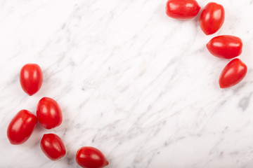 Cherry tomatoes on a white marble background with copy space