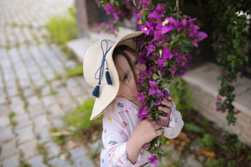 cute little girl in a hat with purple flowers