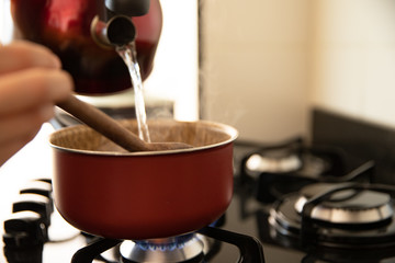 putting boiled water to cook rice