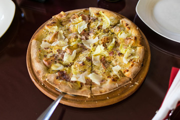 Freshly made pizza on the table. Preparing to eat.