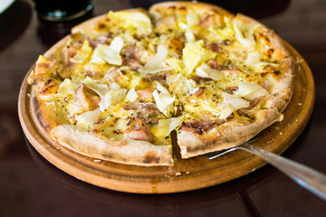 Freshly made pizza on the table. Preparing to eat.