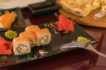 A hand with chopsticks takes sushi.