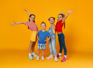 group of cheerful happy children on colored yellow background.