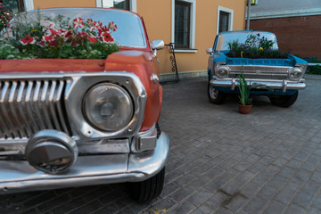 Vintage cars. Car in the square. The flowers in the car.