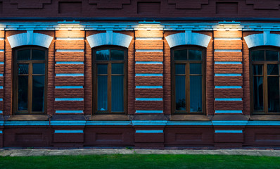 Brick wall with Windows. Night illumination of the building.