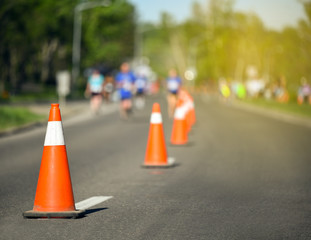 Pylon cones during a marathon with runners in background and yellow glow