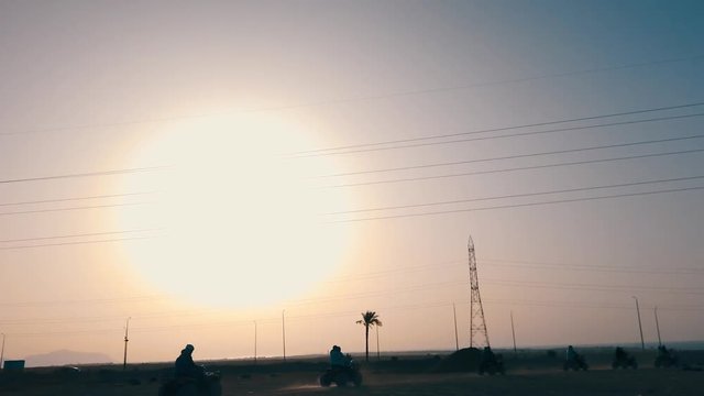 Group of quad bike racers driving in desert
