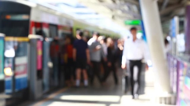 Blurry of people walking to getting on and getting out electric skytrain with automatic gateway, railroad transportation for passenger in city, traveler and urban lifestyle. BTS.