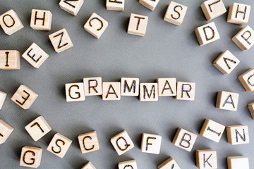 the word grammar wooden cubes with burnt letters, study of grammar of different languages,  gray...