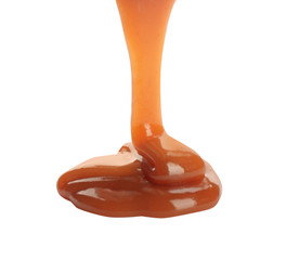 Pouring sweet caramel sauce on white background