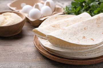 Wooden plate with corn tortillas on table, space for text. Unleavened bread
