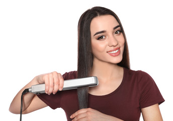 Happy woman using hair iron on white background