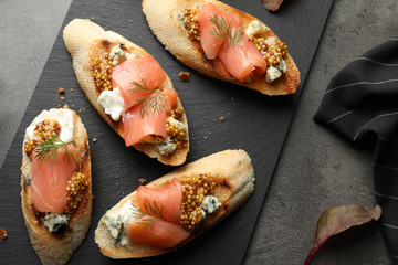 Flat lay composition with tasty bruschettas on grey table. Space for text