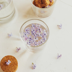 Fototapeta na wymiar Water is infused with purple spring lilac flowers 