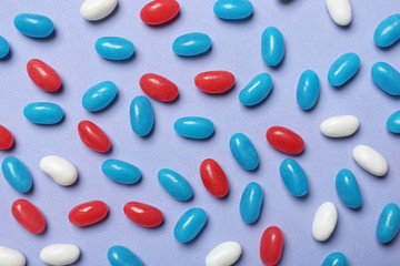 Many delicious jelly beans on color background, flat lay