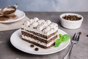 Plate of delicious tiramisu cake on grey table