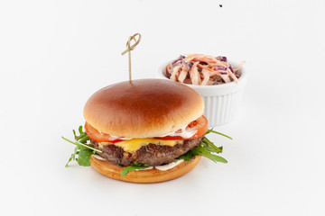 Burger with grilled beef chop, arugula and cheddar cheese served with coleslaw on white background??