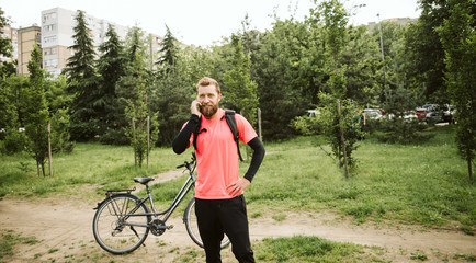  Cyclist in the park. Phone and bicycle