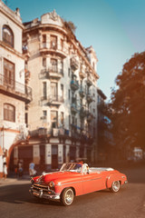 Fototapeta na wymiar Pink classic car and old buildings in downtown Havana