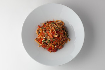 Spaghetti with vegetables and tomato sauce isolated on white background
