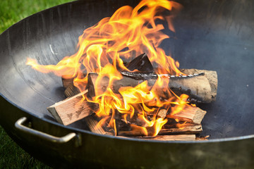 Logs on fire covered in burn marks during cookout