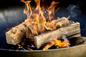 Burning logs flaming in a barbecue fire