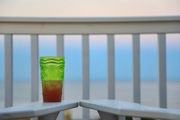 Enjoy a beverage while looking out over the beach and ocean at sunset. in this tropical travel vacation image.