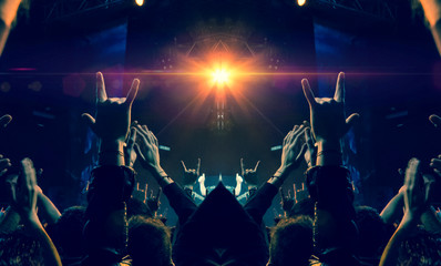 Concert spectators in front of a bright stage with live music