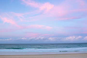 pretty pastel colour sky pink purple blue with fluffy cloud on beach with white sand Australia Gold Coast