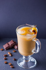 Copper coffee pot (Cezve) and coffee beans. Coffee with milk on dark background. Latte and black chocolate on slate board. Milk drink in glass beaker and dried rose