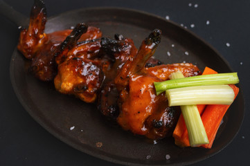 alitas de pollo sobre un fondo negro