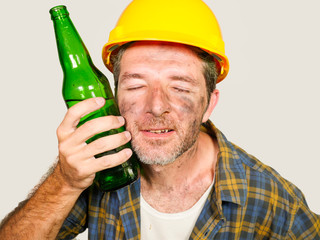 thirsty and tired constructor worker or builder man in safety helmet feeling exhausted holding cold...