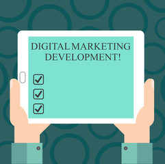 Writing note showing Digital Marketing Development. Business photo showcasing Leverage the digital channels in marketing Hu analysis Hand Holding Tablet Smartphone Display Unit photo