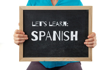 Child holding blackboard with Let's Learn Spanish text