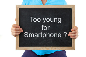 The topic of when to give your children smartphones depicted with child holding blackboard with text