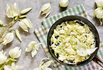 Fried yucca flower petals with eggs and tomatoes. national cuisine of Costa Rica. edible flowers recipe. Yucca is the national flower of Costa Rica