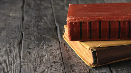 Two very old books on a black wooden table.