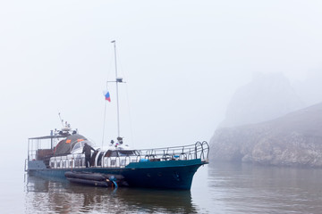 Lake Baikal in summer. Rainy and misty weather on Olkhon Island. A ship at the coast in the Khuzhir bay awaits good weather